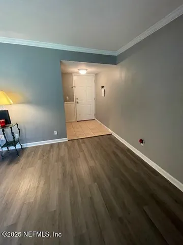 an empty room with wooden floor and natural light