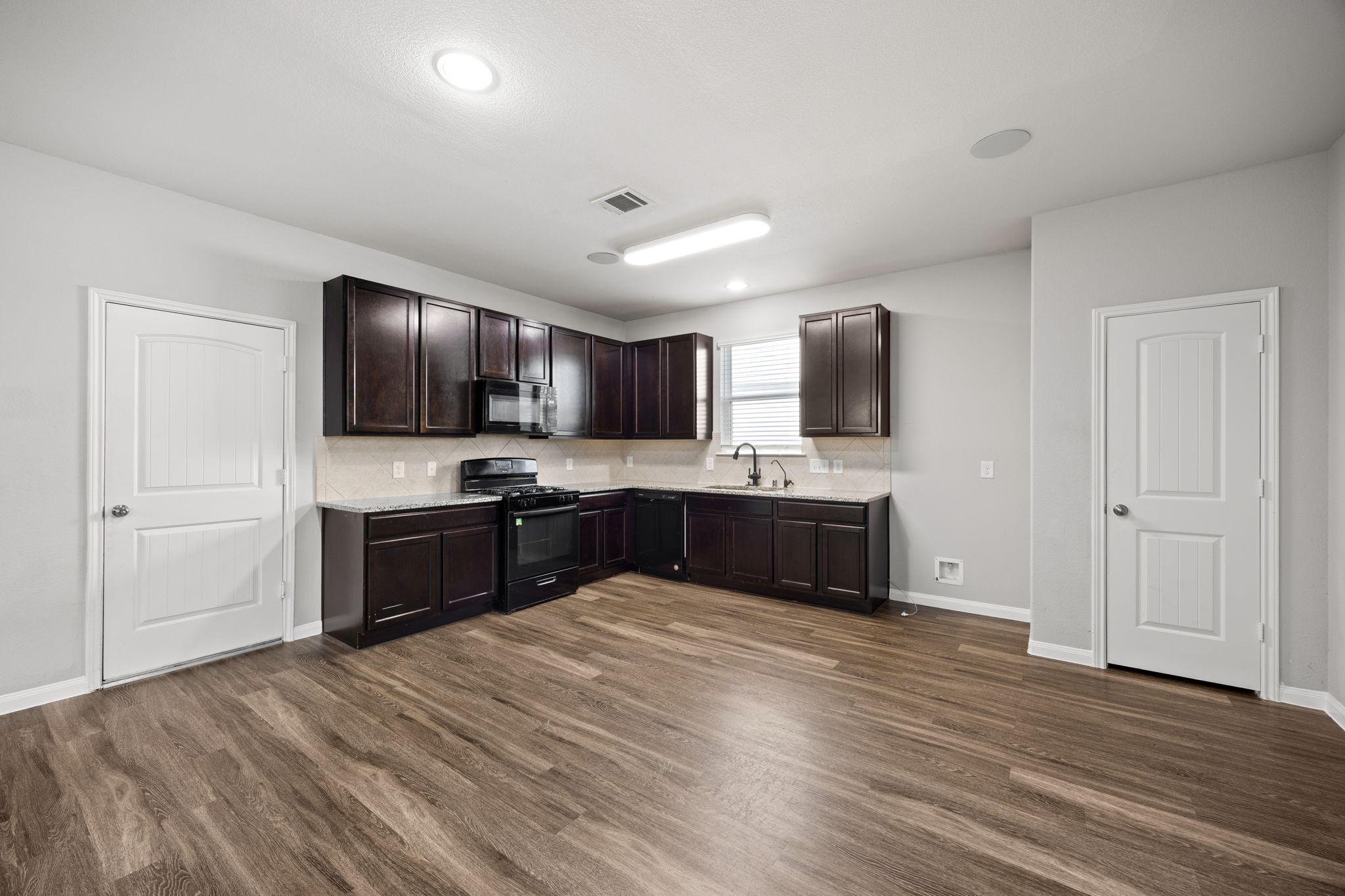 18606 Lansdowne Stream Path Katy, TX 77449 - Photo 19 of 39 a large kitchen with kitchen island granite countertop stainless steel appliances and wooden cabinets