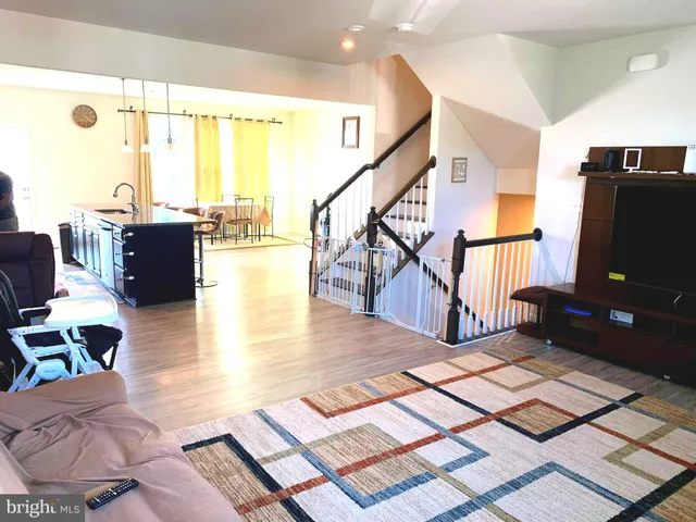 a kitchen with granite countertop a dining table chairs and a stove