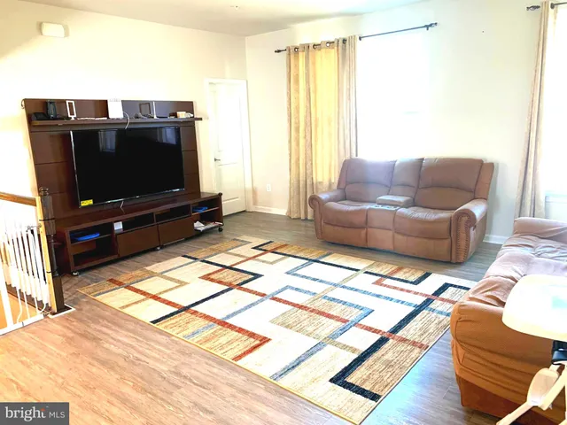 a kitchen with stainless steel appliances kitchen island granite countertop a table chairs and a wooden floor