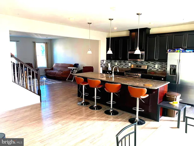 a kitchen with granite countertop a stove a sink and a microwave