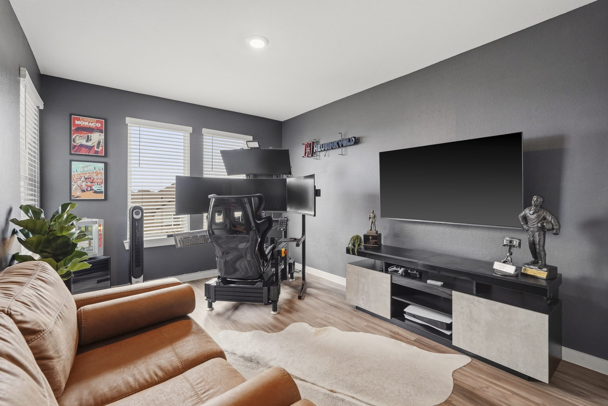 22522 Modica Rift Lane Katy, TX 77449 - Photo 28 of 38 This bold, personality-packed bedroom doubles as the ultimate hobby or gaming retreat. Deep charcoal walls set a dramatic tone, while a multi-monitor racing simulator setup, large wall-mounted TV, and leather sofa create a space that's equal parts functional and seriously fun. Whether it becomes a dedicated gamer's haven, a media room, or a creative studio, this room has the bones — and the attitude — to be whatever you need it to be.