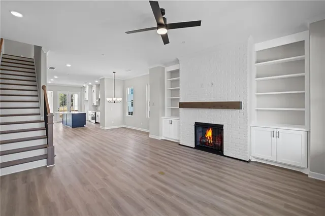 a view of an empty room with wooden floor fire place and a fireplace