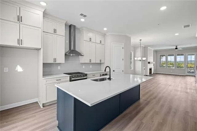 a kitchen with stainless steel appliances a sink stove and wooden floor