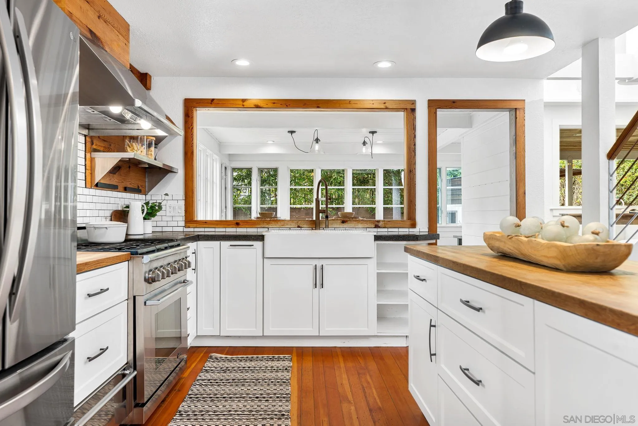 445 Sheffield Avenue Cardiff, CA 92007 - Photo 19 of 62 a kitchen with stainless steel appliances granite countertop a stove a sink and a granite counter tops with white cabinets