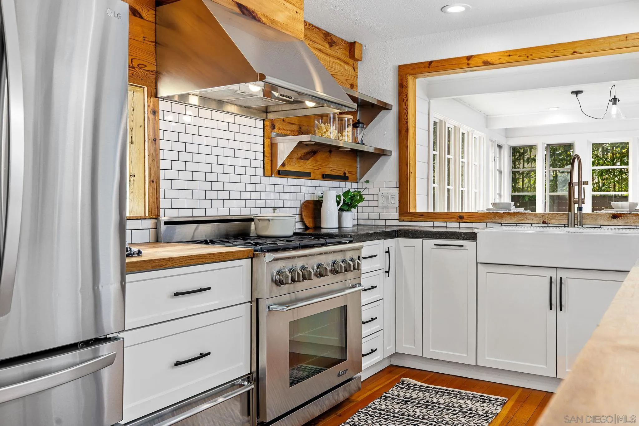 445 Sheffield Avenue Cardiff, CA 92007 - Photo 20 of 62 a kitchen with stainless steel appliances granite countertop white cabinets and a stove top oven