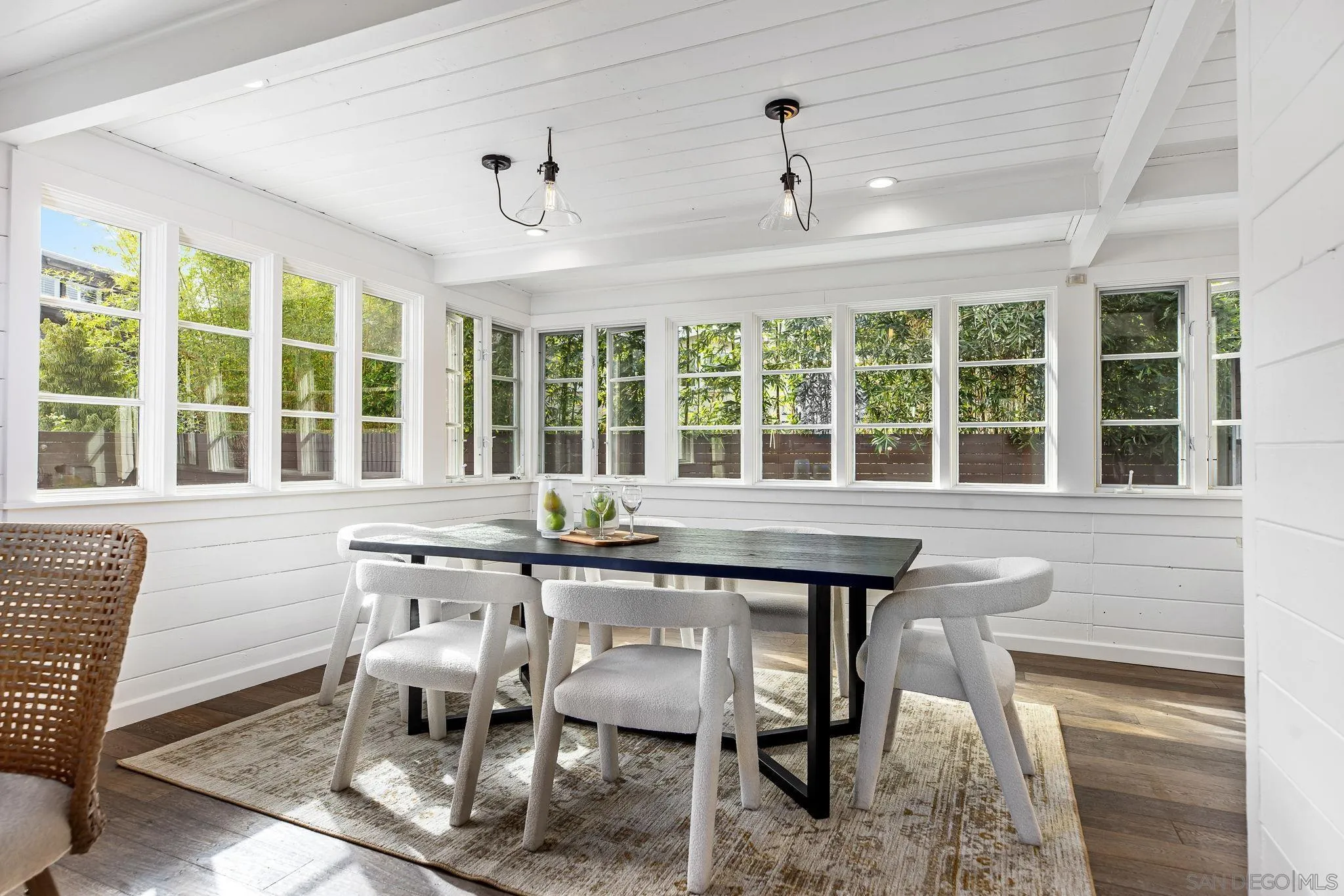 445 Sheffield Avenue Cardiff, CA 92007 - Photo 22 of 62 a dining room with wooden floor a chandelier a glass table and chairs