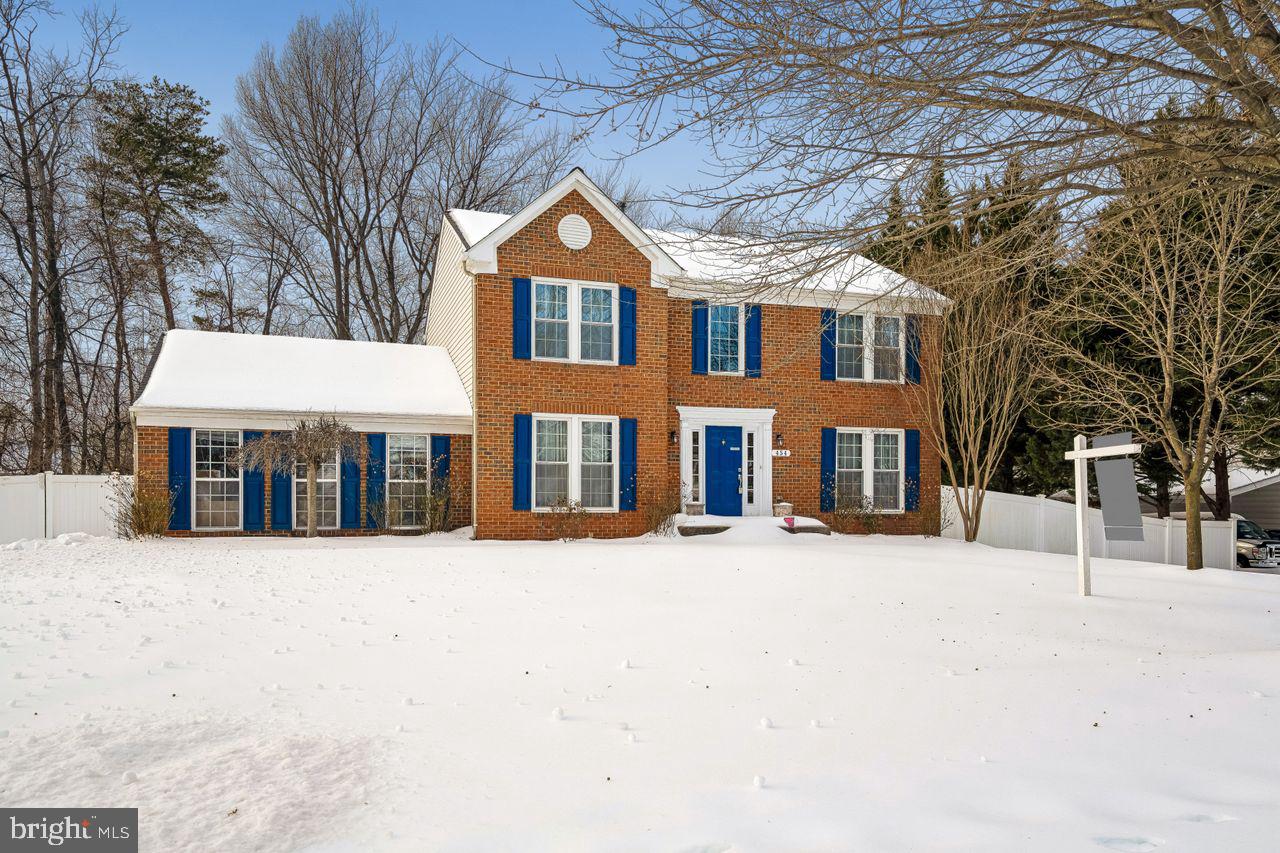 a front view of a house with a yard covered in snow