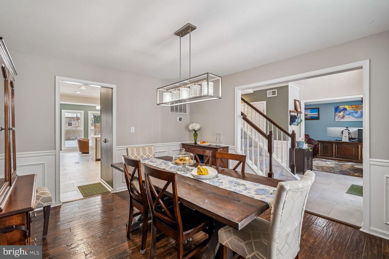 454 North Patuxent Road Odenton, MD 21113 - Photo 5 of 41 a dining room with wooden floor a chandelier a wooden table and chairs