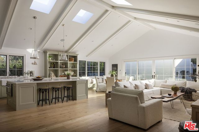 a living room with furniture a large window and wooden floor