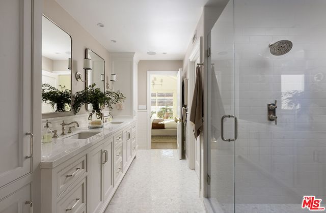 a bathroom with double vanity sink and a mirror