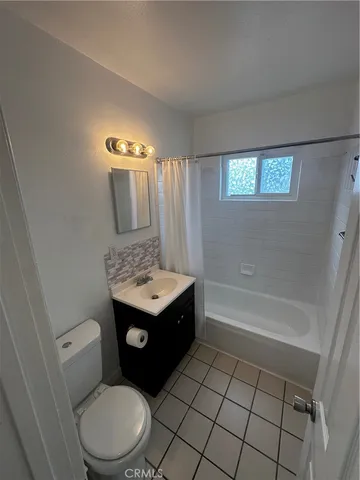 a bathroom with a granite countertop toilet sink and mirror