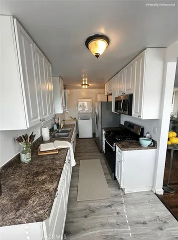 a large kitchen with stainless steel appliances granite countertop a stove a sink dishwasher and a microwave