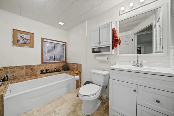 a bedroom with a bed and a dresser next to a window