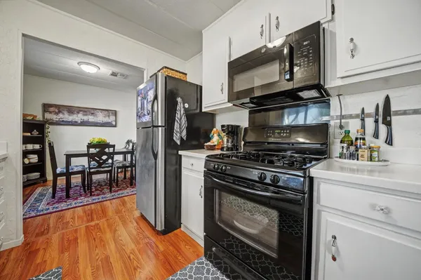 a kitchen with stainless steel appliances granite countertop a stove refrigerator and a microwave