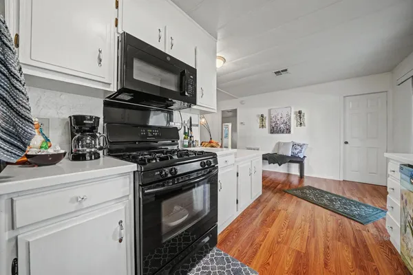a kitchen with stainless steel appliances a stove microwave and cabinets