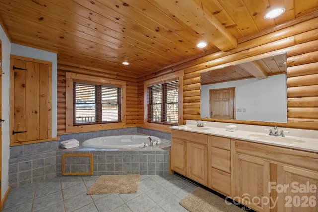 a spacious bathroom with a tub sink and mirror