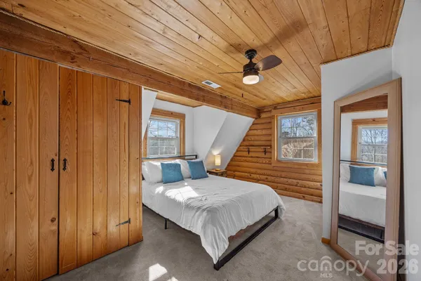 a bedroom with a bed wooden floor and window