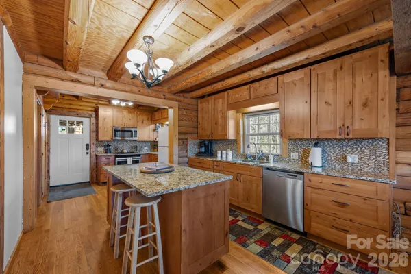 a kitchen with stainless steel appliances granite countertop a sink stove and cabinets