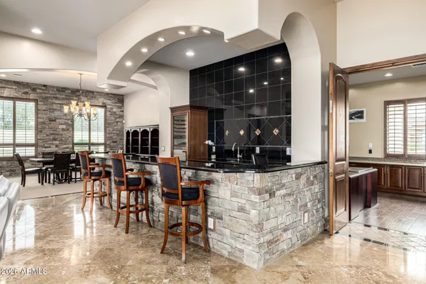 a bathroom with a granite countertop double vanity sink mirror and shower