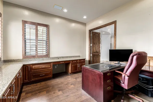 a view of a workspace with furniture and a window