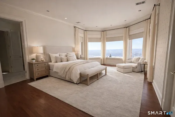 a spacious bedroom with a bed and wooden floor
