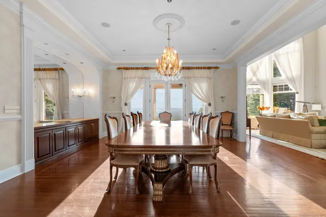 a very nice looking dining room with furniture a chandelier and wooden floor