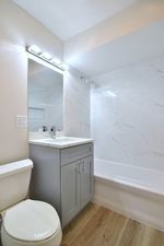 6060 North Ridge Avenue, Unit 1A Chicago, IL 60660 - Photo 17 of 25 a bathroom with a sink mirror vanity and toilet