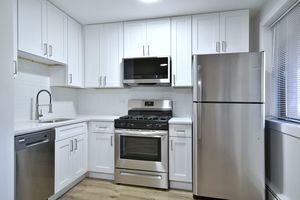 6060 North Ridge Avenue, Unit 1A Chicago, IL 60660 - Photo 3 of 25 a kitchen with white cabinets and stainless steel appliances