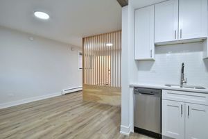6060 North Ridge Avenue, Unit 1A Chicago, IL 60660 - Photo 5 of 25 a kitchen with granite countertop white cabinets and a hard wood floor