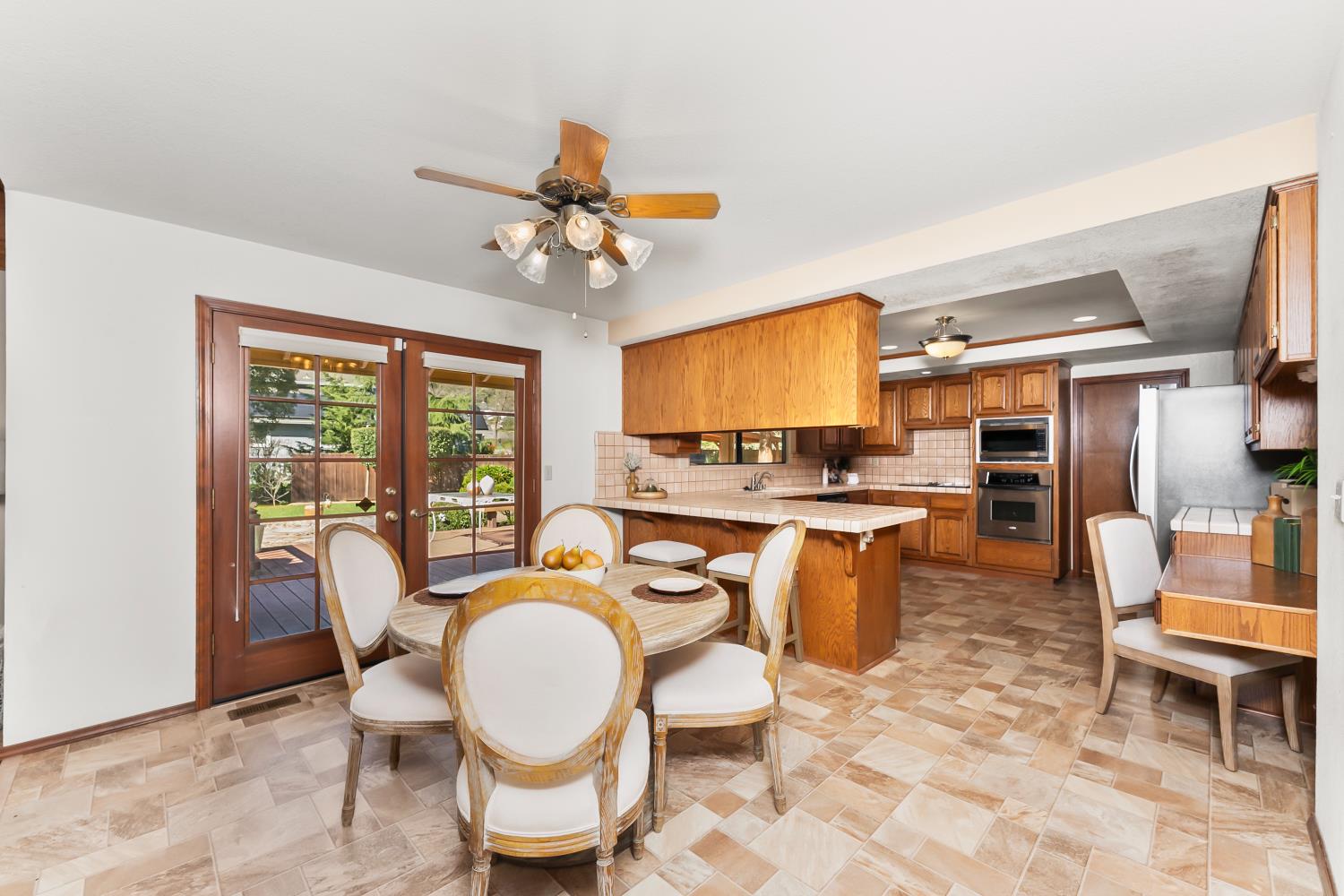 3708 Millbrae Road Cameron Park, CA 95682 - Photo 11 of 48 a dining room with furniture a floor to ceiling window and kitchen view