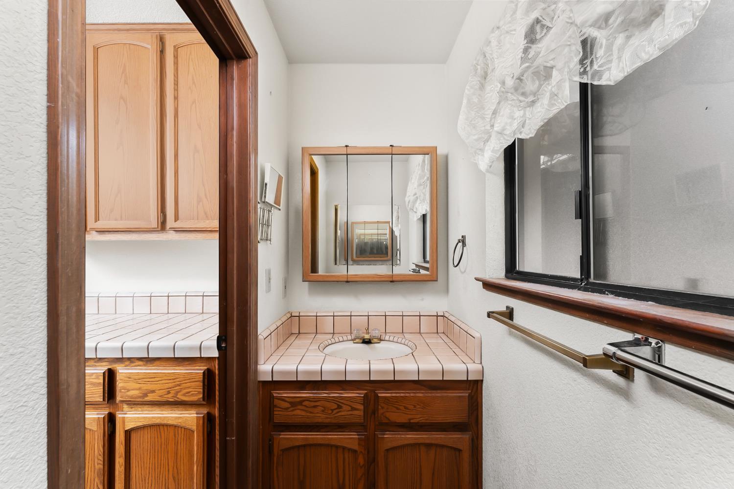 3708 Millbrae Road Cameron Park, CA 95682 - Photo 26 of 48 a bathroom with a granite countertop sink and a mirror