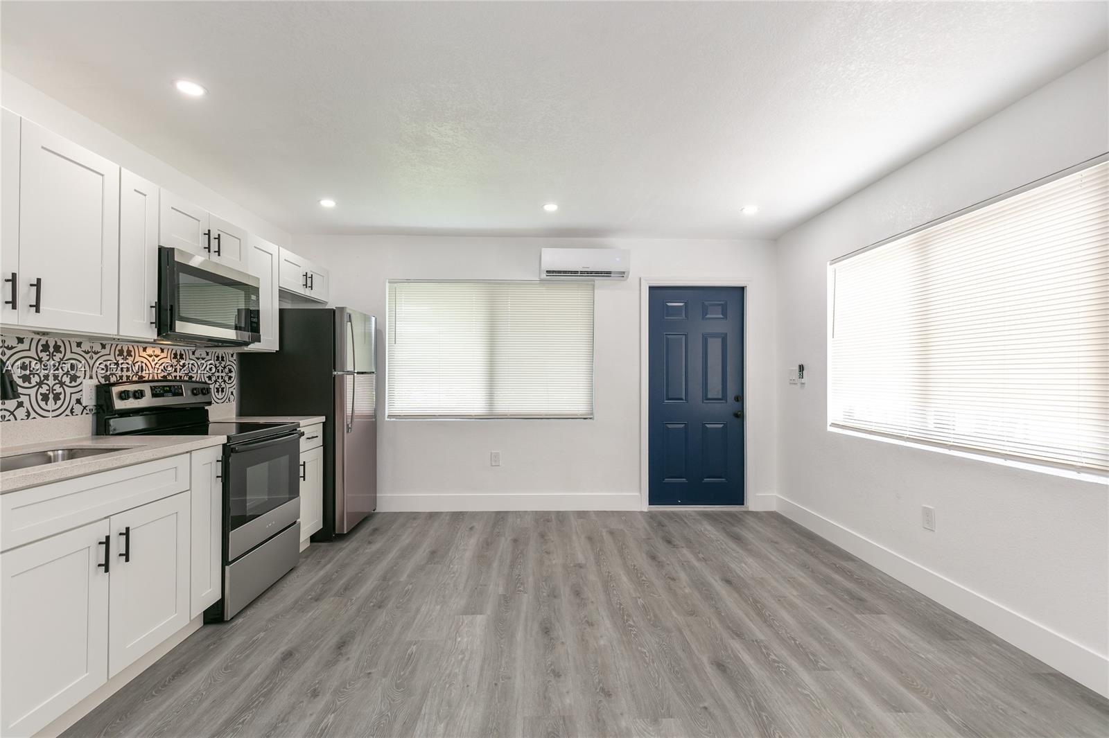 6125 Southwest 40th Court Miramar, FL 33023 - Photo 13 of 43 a kitchen with a refrigerator wooden floor and white cabinets