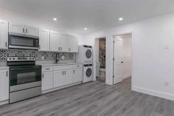 a kitchen with stainless steel appliances granite countertop a stove a sink and a refrigerator