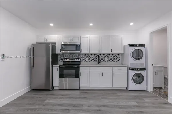 a kitchen with a refrigerator a stove top oven and cabinets