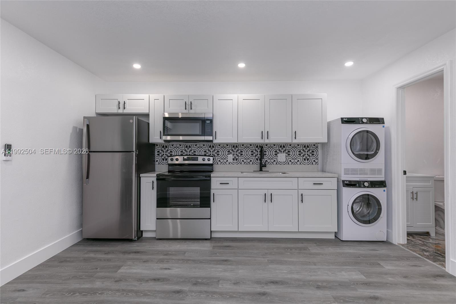 6125 Southwest 40th Court Miramar, FL 33023 - Photo 16 of 43 a kitchen with a refrigerator a stove top oven and cabinets