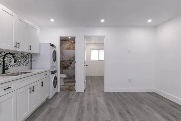 a kitchen with a sink and wooden floor