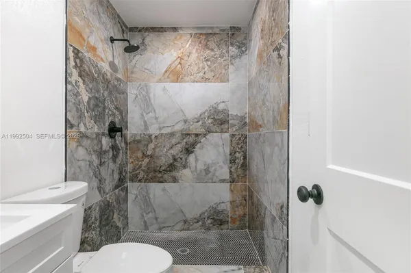 a bathroom with a toilet and a shower