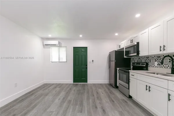 a kitchen with a refrigerator and a stove top oven