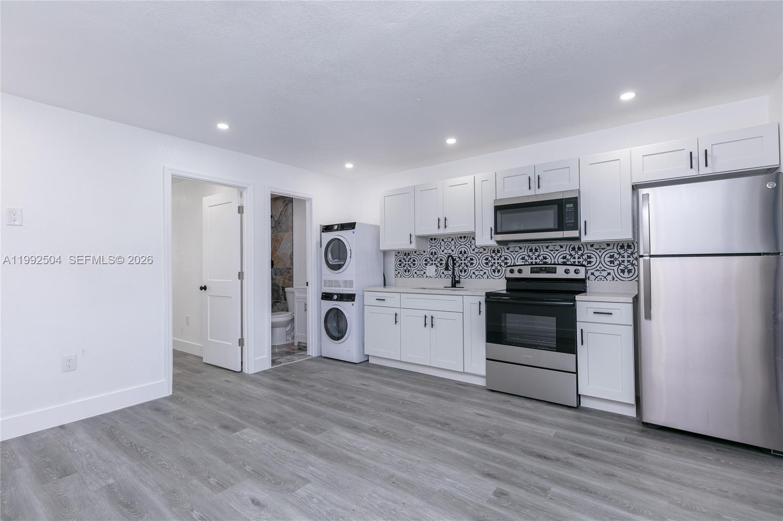 6125 Southwest 40th Court Miramar, FL 33023 - Photo 23 of 43 a kitchen with a refrigerator a stove top oven and white kitchen