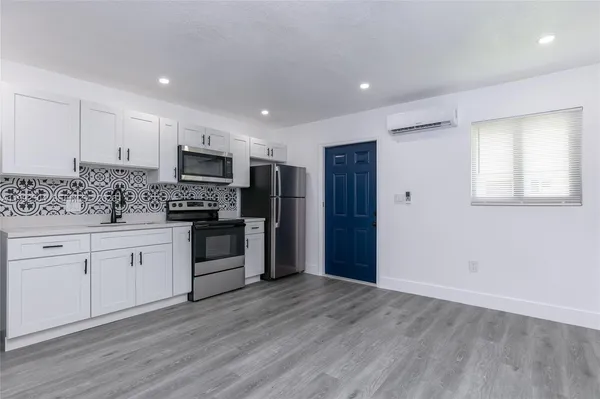 a large kitchen with stainless steel appliances granite countertop a stove a sink and a refrigerator