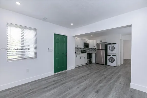 a view of kitchen with stainless steel appliances granite countertop a refrigerator and a stove