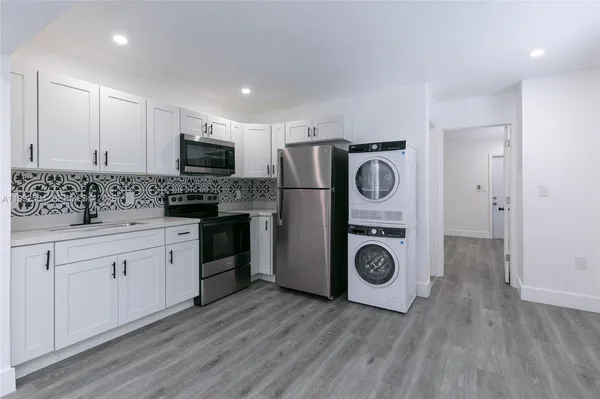 a kitchen with stainless steel appliances granite countertop a stove a refrigerator and a microwave