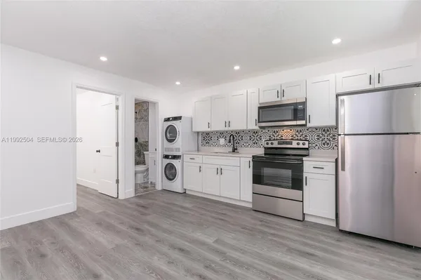 a kitchen with a refrigerator stove and white cabinets