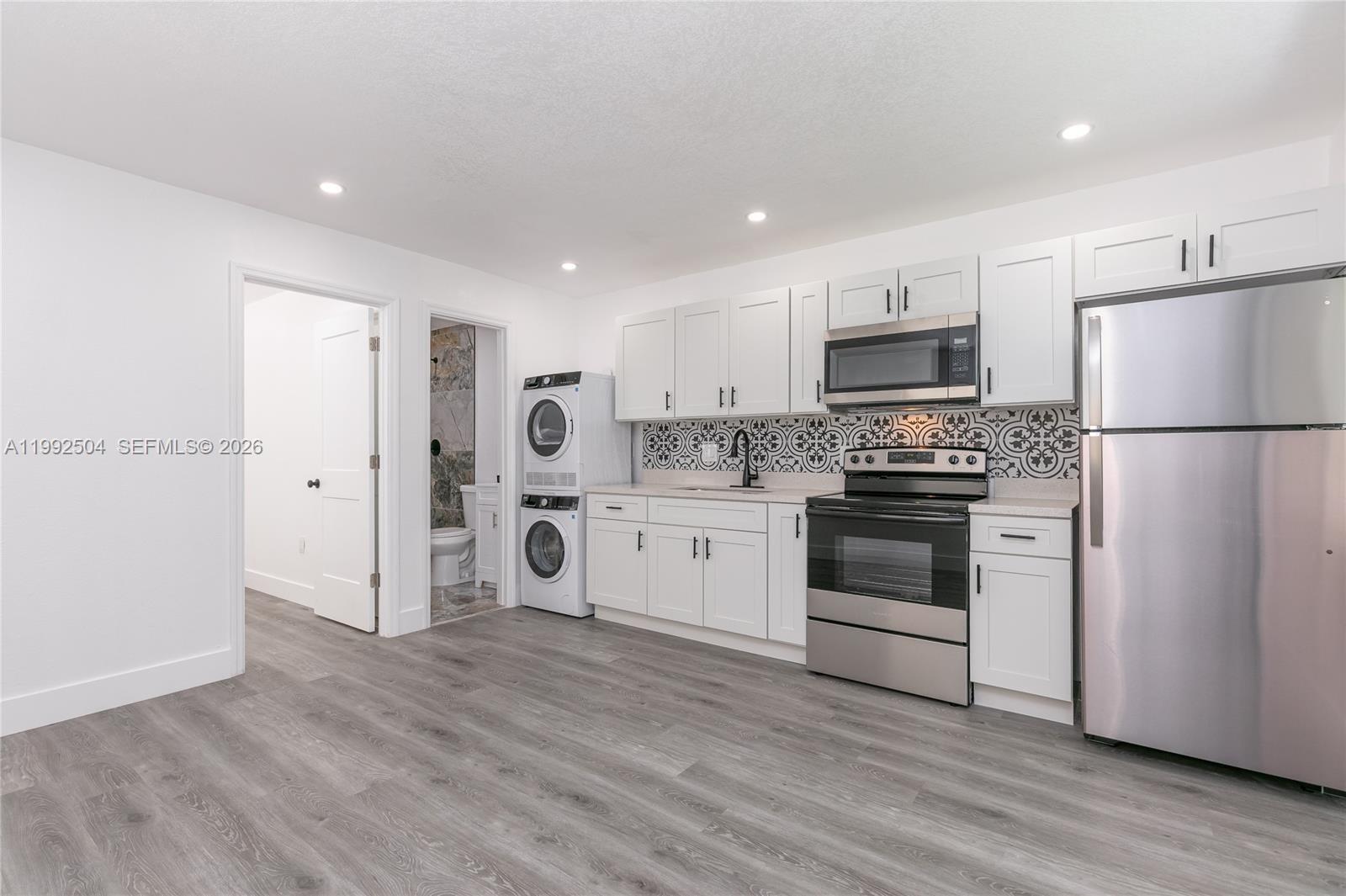 6125 Southwest 40th Court Miramar, FL 33023 - Photo 7 of 43 a kitchen with a refrigerator stove and white cabinets