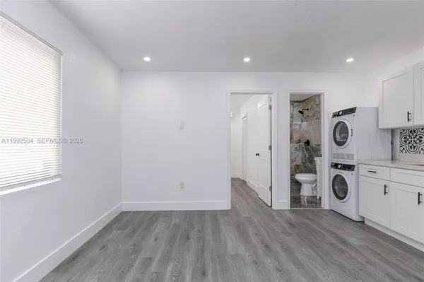 a view of a kitchen with fridge and wooden floor