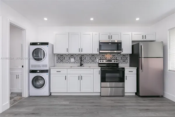 a kitchen with a refrigerator and a stove top oven