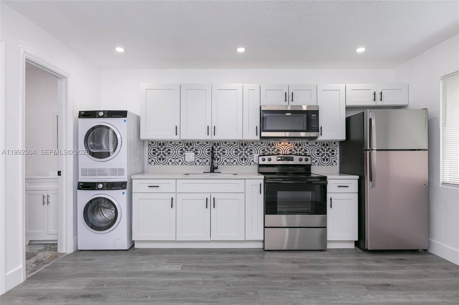 6125 Southwest 40th Court Miramar, FL 33023 - Photo 9 of 43 a kitchen with a refrigerator and a stove top oven