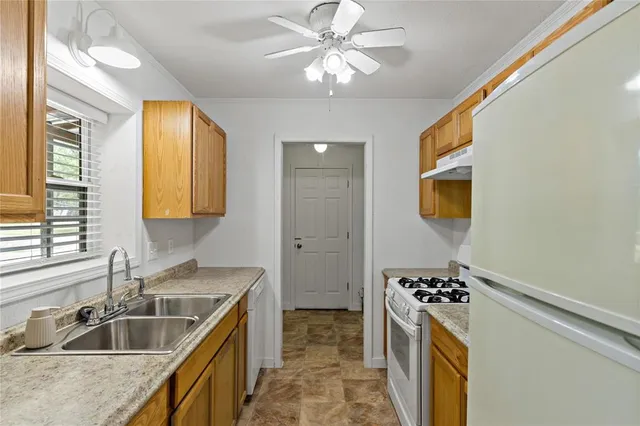 a kitchen with stainless steel appliances granite countertop a sink a stove and a refrigerator