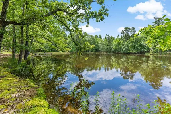 a backyard of a house with table and chairs under an umbrella